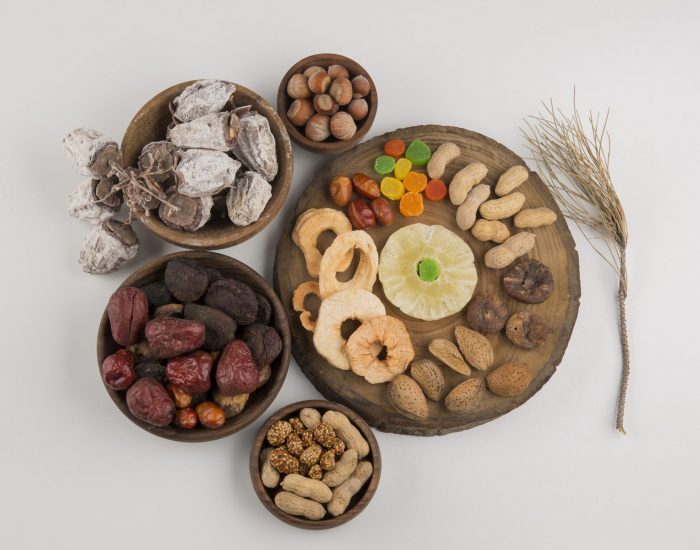 Dry fruits and snacks in multiple wooden platters and saucers in the center. High quality photo